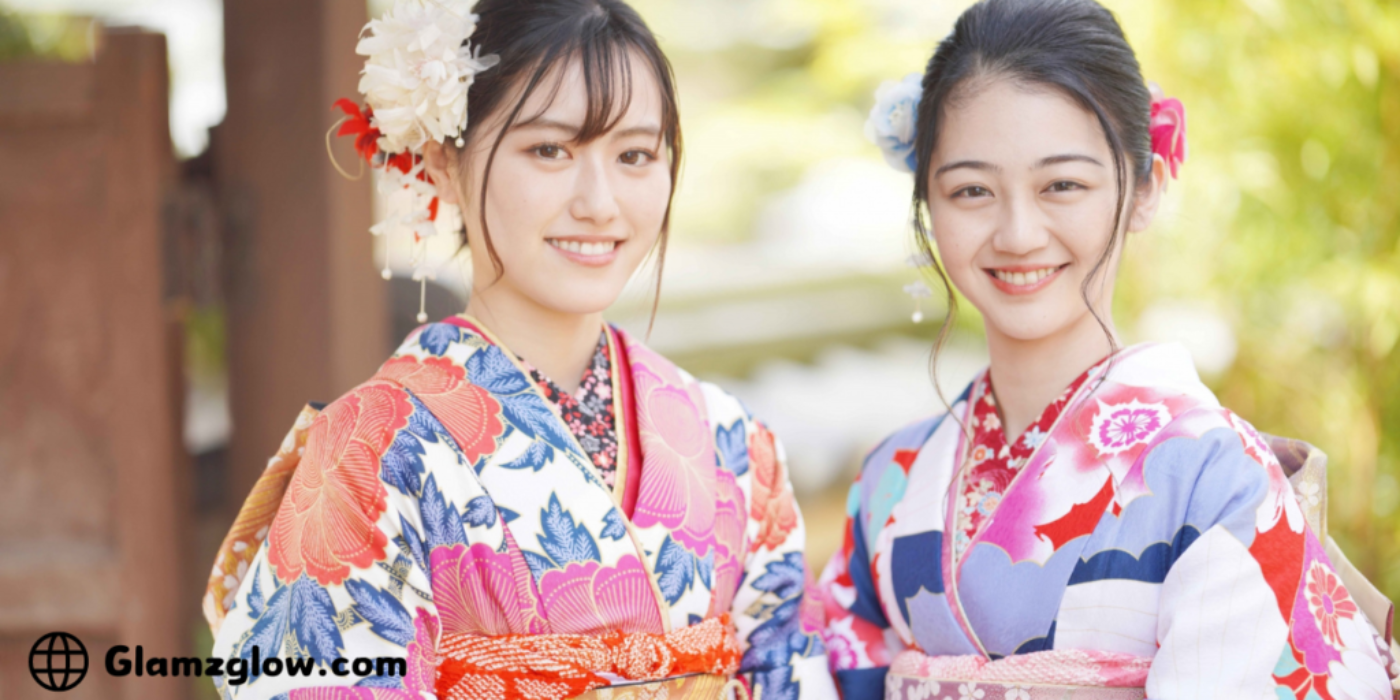 Two women wearing colorful traditional Japanese kimonos with floral patterns and hair accessories, smiling at the camera.